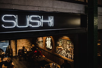 Neon Sushi Sign Above Restaurant Interior at Night