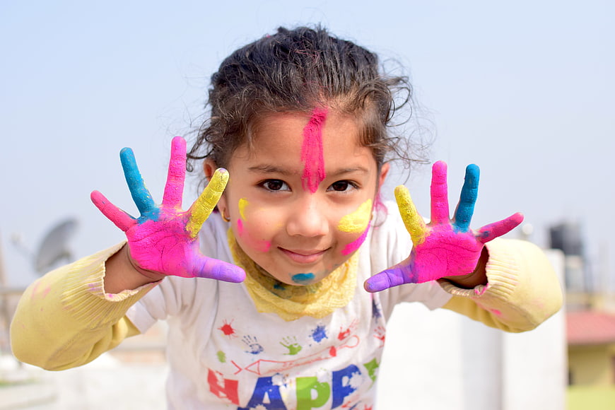 Happy Girl with Colorful Hands Celebrating Holi Festival