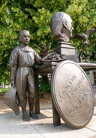 Bronze Sculpture of Boy and Giant Head in Park