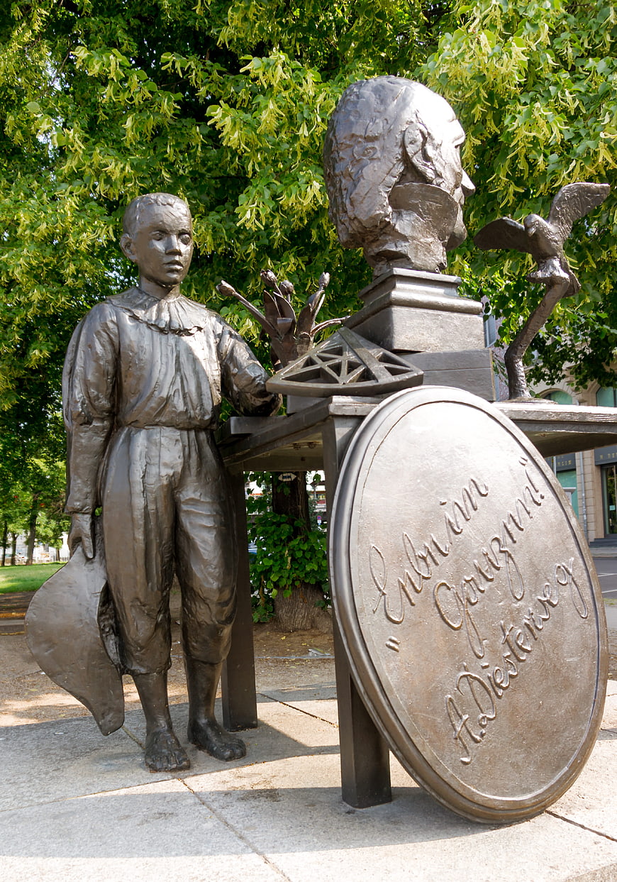 Bronze Sculpture of Boy and Giant Head in Park
