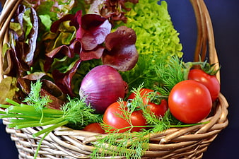 Fresh vegetable basket with tomatoes, red onion, lettuce, and dill