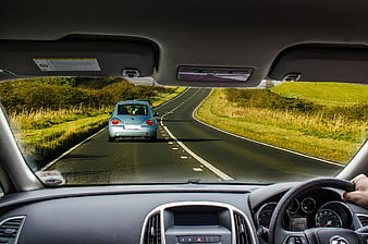 POV Driving on Winding Country Road Behind Blue Car