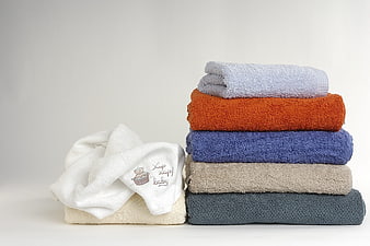Stacked colorful bath towels and baby towel on white background