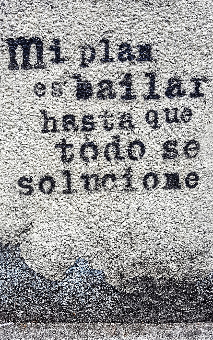 Spanish street art quote on textured concrete wall