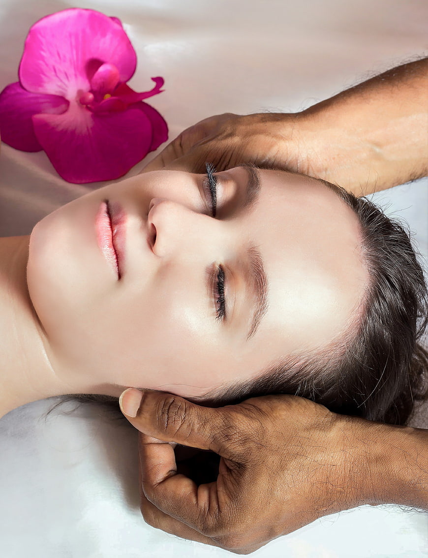 Woman Receiving Head Massage With Orchid