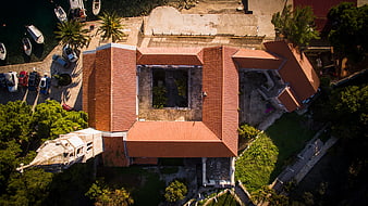 Aerial view of historic stone building with red tiled roof