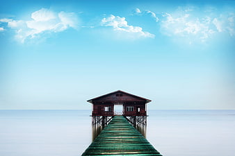 Serene Wooden Pier Extending to Cabin Over Calm Ocean