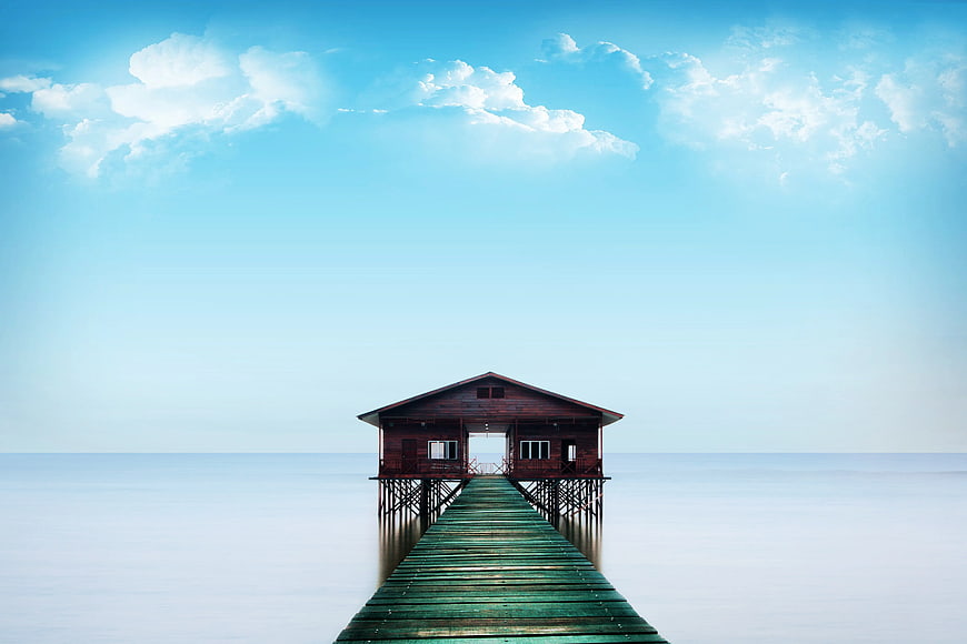 Serene Wooden Pier Extending to Cabin Over Calm Ocean
