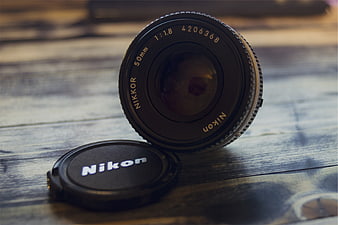 Vintage Nikon 50mm Lens on Wooden Table