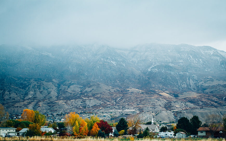 Autumn landscape with colorful trees and misty mountains