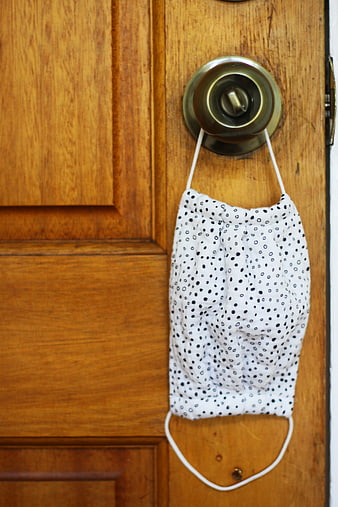 White Polka Dot Face Mask Hanging on Wooden Door Knob