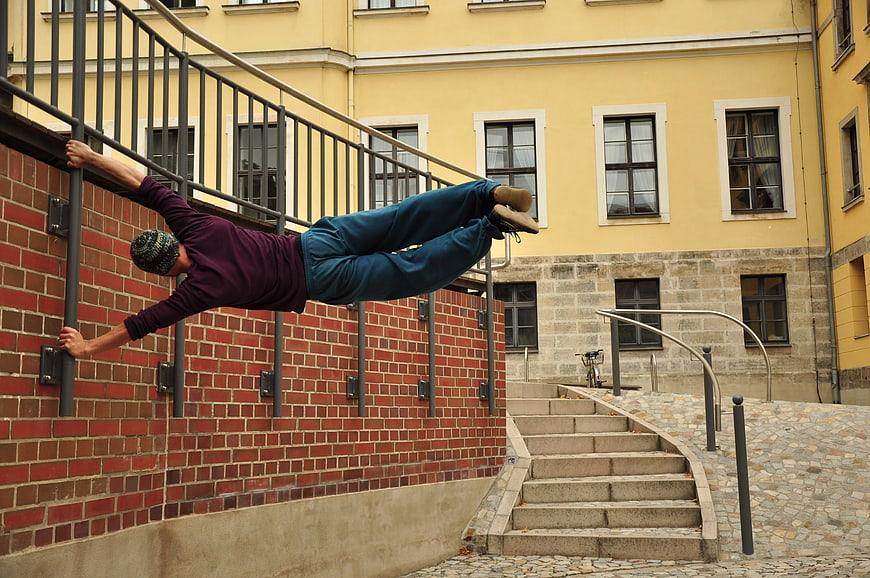Man Performing Parkour Wall Run on Urban Stairs