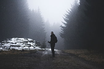 Lone Hiker Standing in Foggy Forest Path