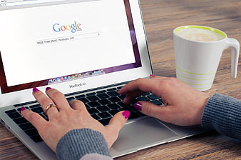Woman Typing on MacBook Air with Coffee