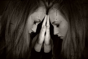 Two women in profile with hands pressed together in black and white