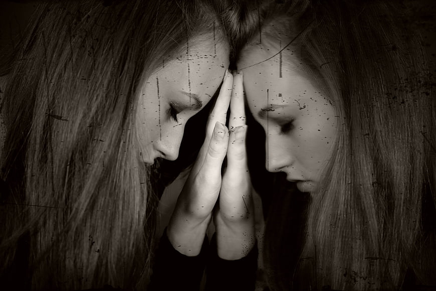 Two women in profile with hands pressed together in black and white