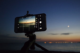 Smartphone on Tripod Capturing Sunset Over Ocean