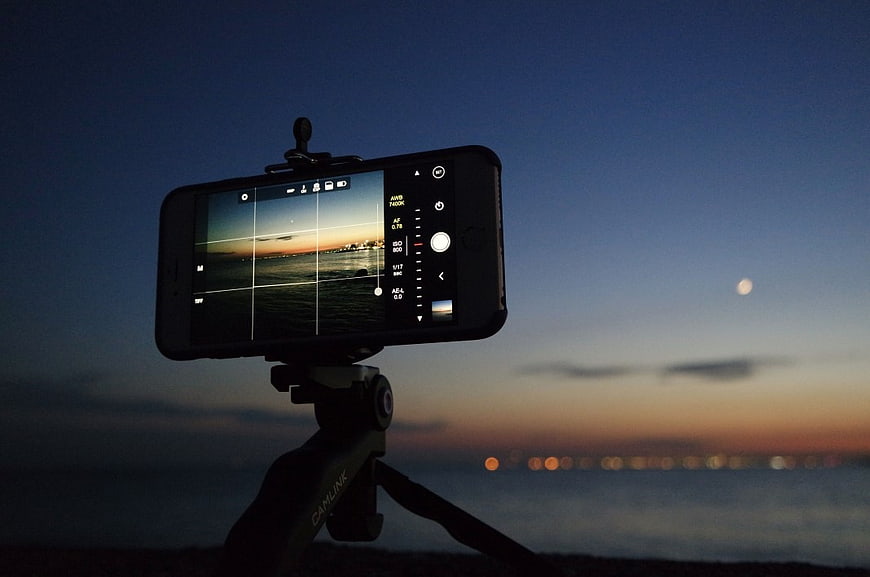 Smartphone on Tripod Capturing Sunset Over Ocean