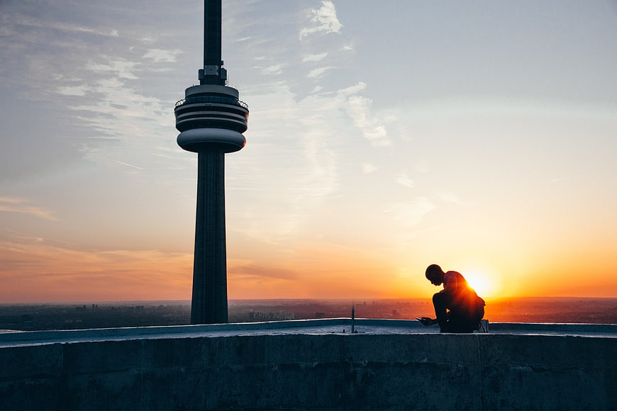 Man Silhouette on Rooftop with TV Tower at Sunset