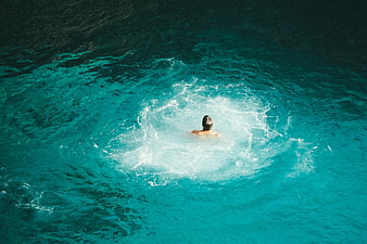 Aerial view of a man swimming in turquoise ocean water