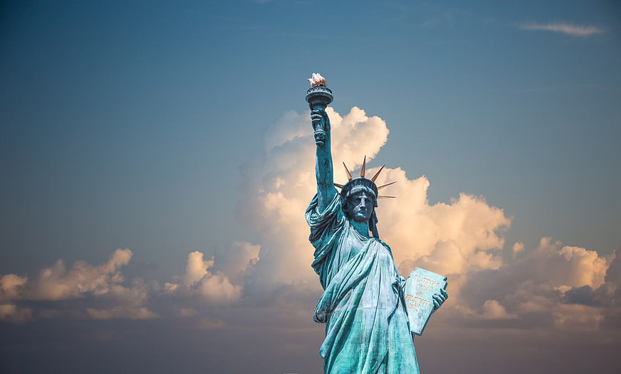 Statue of Liberty against dramatic sunset clouds