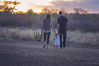 Family Walking Away at Sunset in Countryside