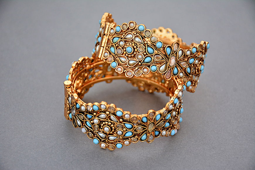 Antique Gold Bangle With Blue And Pearl Gemstone Inlay On Gray Background