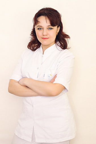 Portrait of female dentist in white uniform with crossed arms