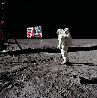 Astronaut standing next to American flag on the moon surface