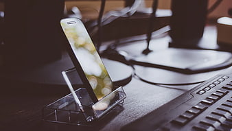 Smartphone on Clear Stand Beside Keyboard