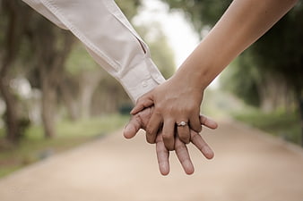 Couple Holding Hands with Engagement Ring on Path