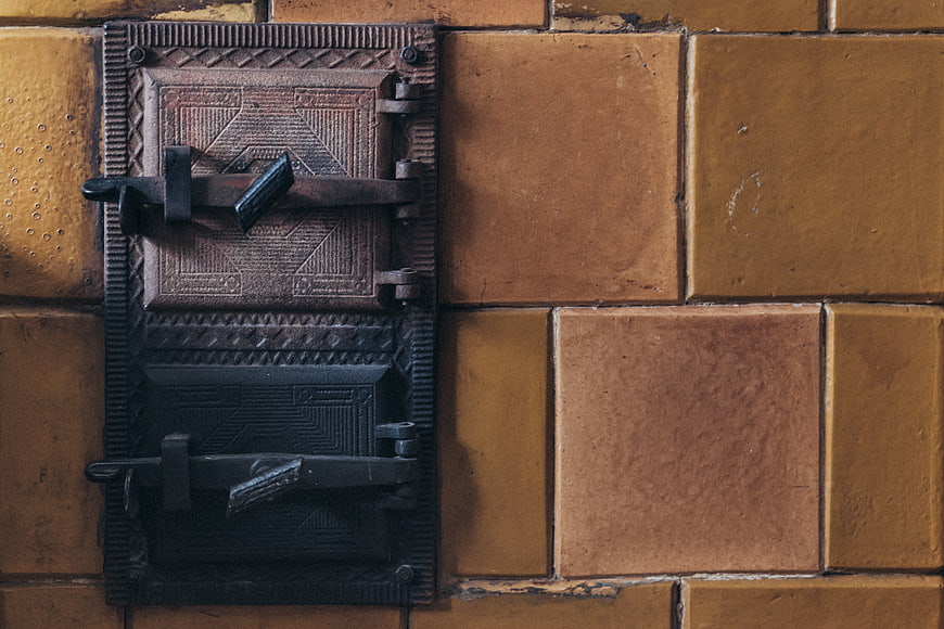 Vintage Cast Iron Stove Door on Yellow Brick Wall