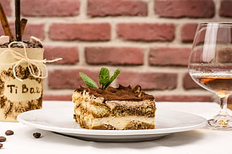 Tiramisu dessert slice with mint garnish and coffee drink