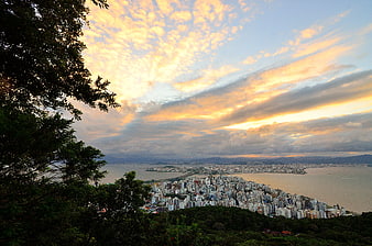 Aerial View of Coastal City at Sunset with Dramatic Clouds