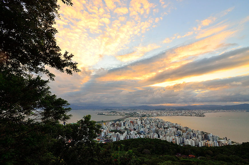 Aerial View of Coastal City at Sunset with Dramatic Clouds