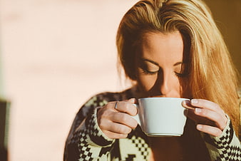 Blonde Woman Sipping Coffee in Patterned Sweater