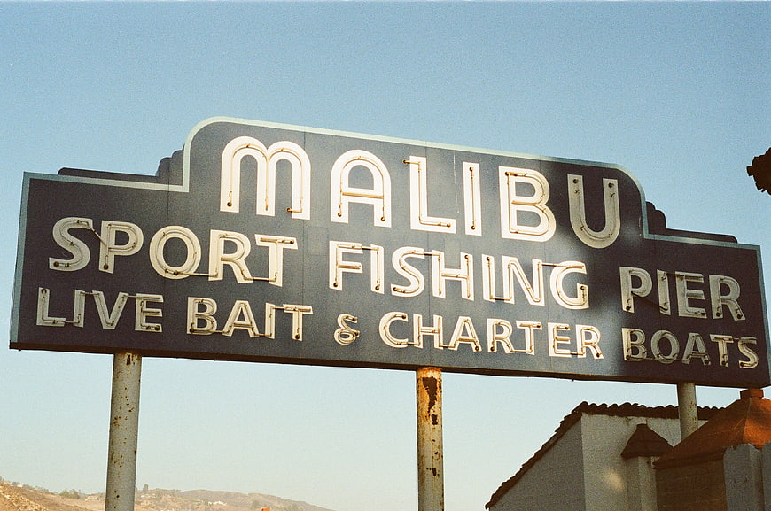 Vintage Malibu Sport Fishing Pier Sign Against Blue Sky