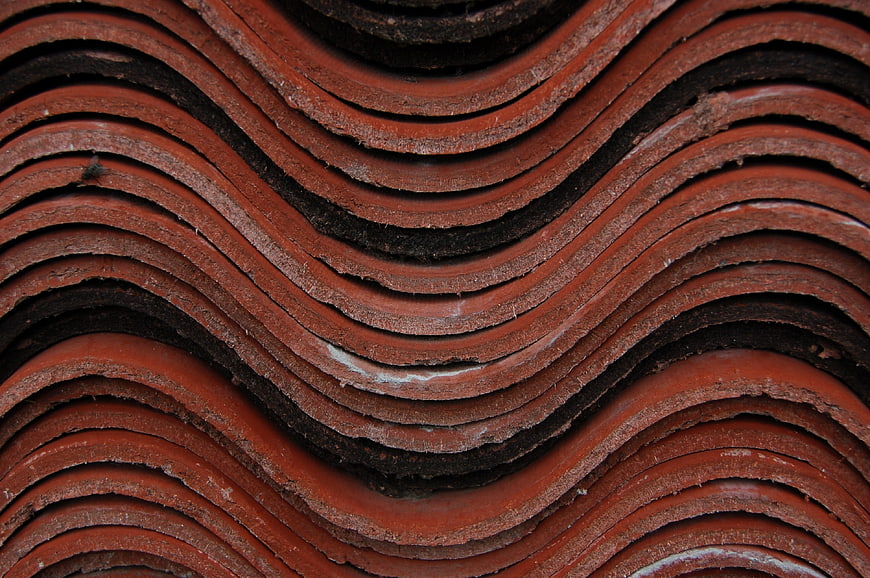 Close-up texture of stacked red terracotta roof tiles
