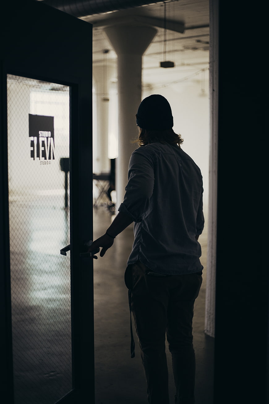Man entering studio through glass door