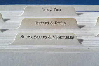 Close-up of vintage recipe book index tabs with food categories