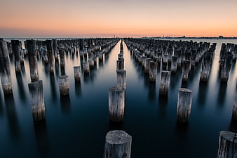 Long Exposure Wooden Pilings in Calm Water at Sunset