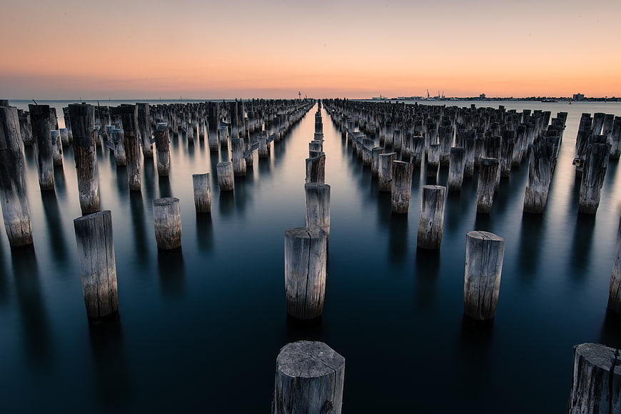Long Exposure Wooden Pilings in Calm Water at Sunset