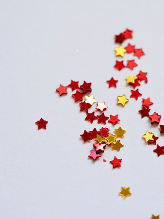 Red and Gold Star Confetti on White Background
