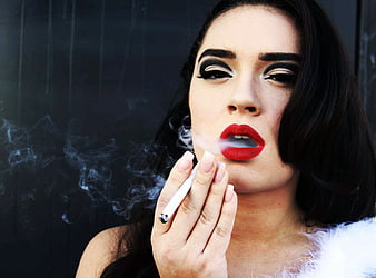 Glamorous woman smoking cigarette with dramatic makeup