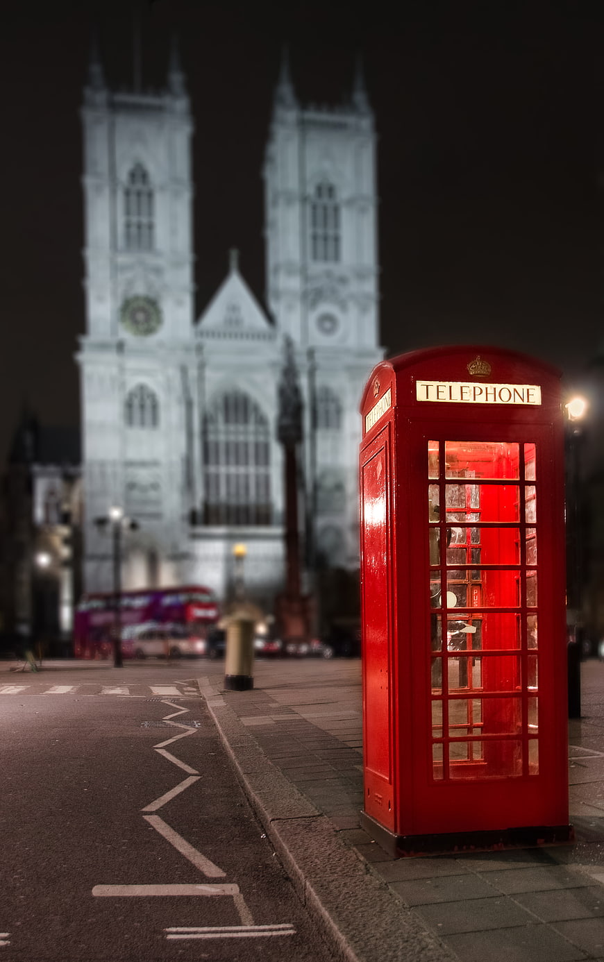 Red Telephone Box in Front of Westminster Abbey at Night
