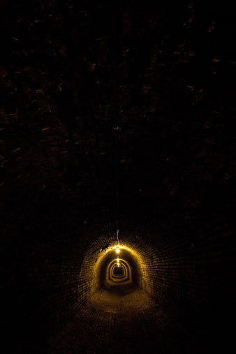 Dark Underground Brick Tunnel With Distant Warm Light