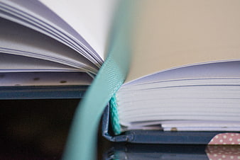 Close-up of open notebook with teal bookmark ribbon