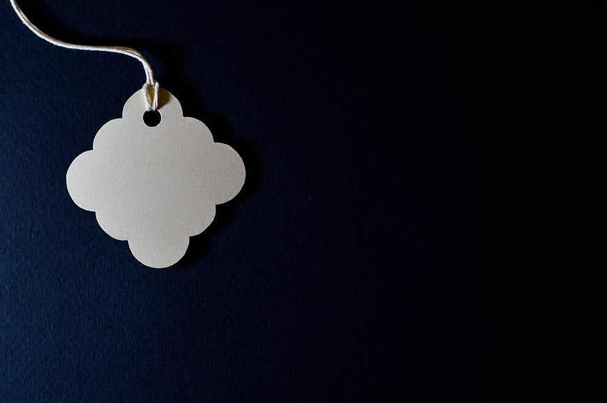 Blank Scalloped Paper Tag with String on Dark Blue Background