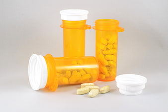 Orange Prescription Bottles with Tablets on White Background