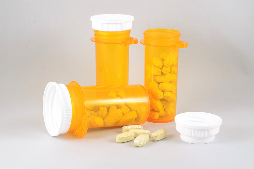 Orange Prescription Bottles with Tablets on White Background